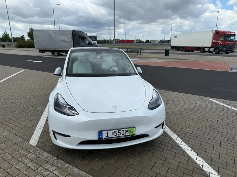 Fehér Tesla Model Y próbarendszámmal pihenőhelyen